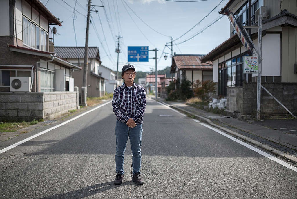 安齋先生站在飯館村空蕩的街道，村在福島第一核電廠西北約30-40公里，10年前是嚴重的核污染災區。一場核災抹掉往昔的鄉情。© Christian Åslund / Greenpeace