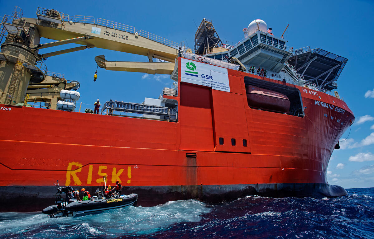 綠色和平除了在太平洋上直接見證全球海洋礦物資源公司進行設備測試，更派出橡皮艇進行直接行動，在船身寫上「風險（RISK）」，警告深海採礦風險處處。© Marten van Dijl / Greenpeace