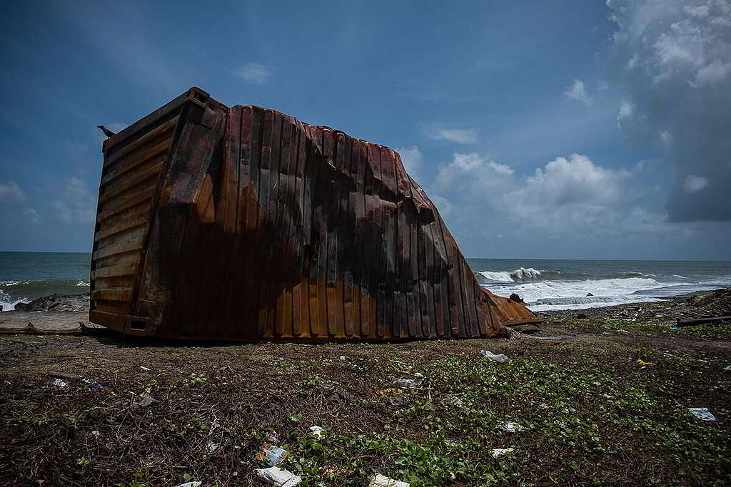 「燒通頂」的貨櫃橫亙海灘，足見爆炸威力驚人。 © Tashiya de Mel / Greenpeace
