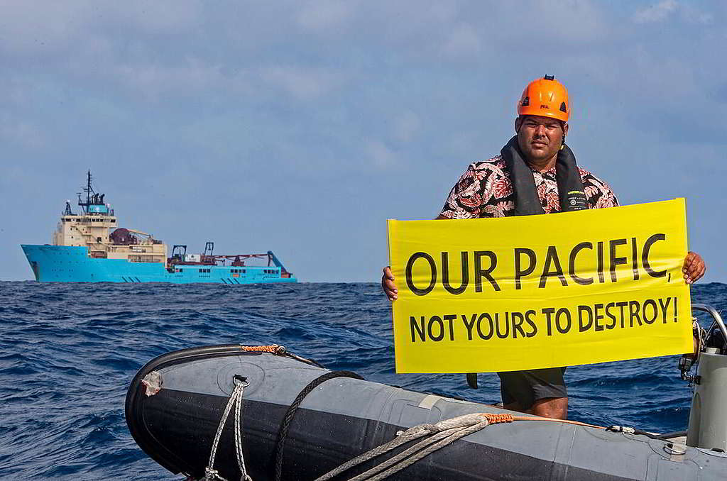 「我們的太平洋，不容你來摧毀！」斐濟行動者Victor隨綠色和平船艦彩虹勇士號監察深海採礦企業一舉一動，並手持標語以直接行動表達訴求。 © Marten van Dijl / Greenpeace