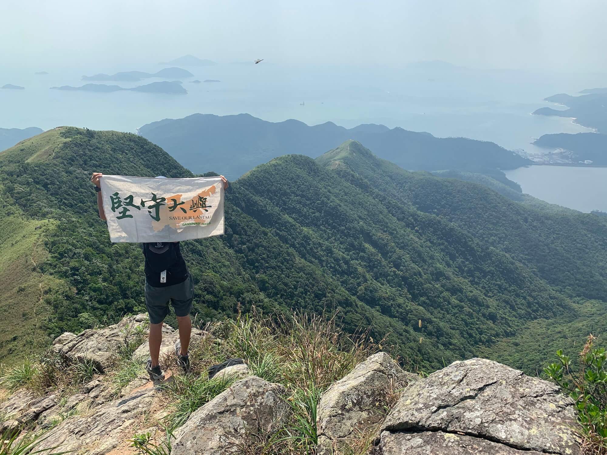 行動者在大嶼山舉起「堅守大嶼旗幟」，展示守護香港青山綠水的決心。© Greenpeace