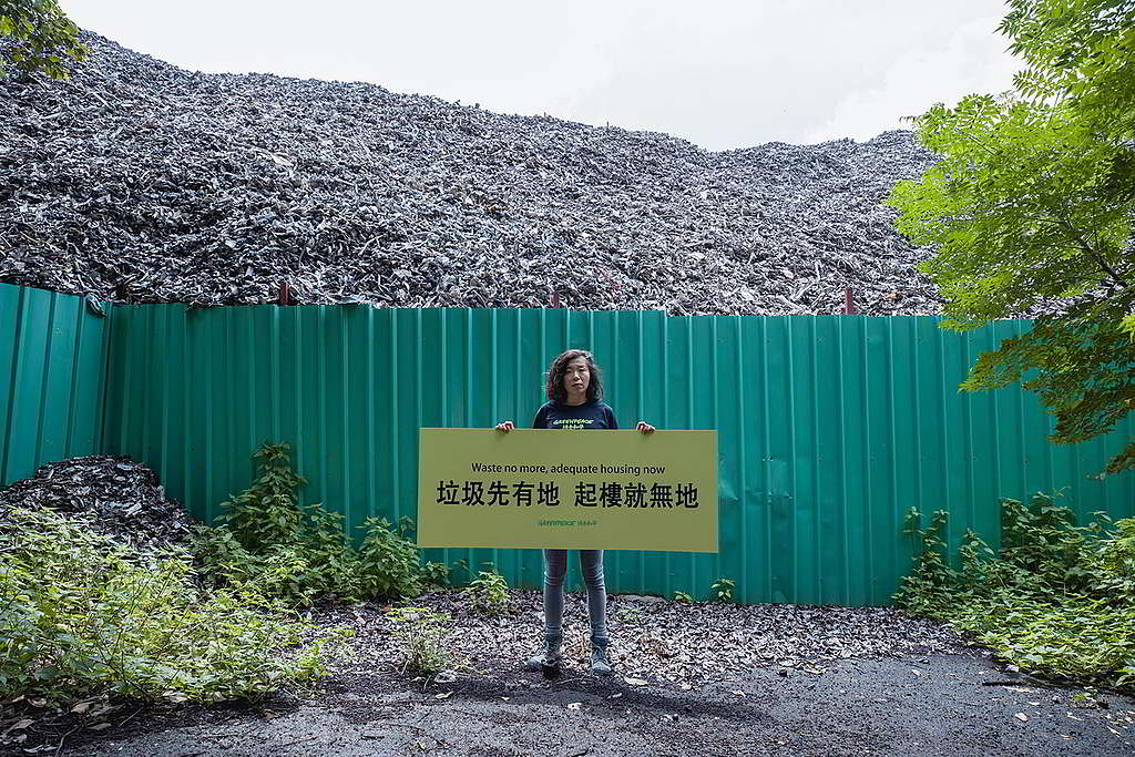 「垃圾先有地 起樓就無地」綠色和平項目主任陳可淳在厦村一座8米高垃圾山前拉起橫額，促請政府馬上全面規劃棕地。 © Greenpeace / Harry Long