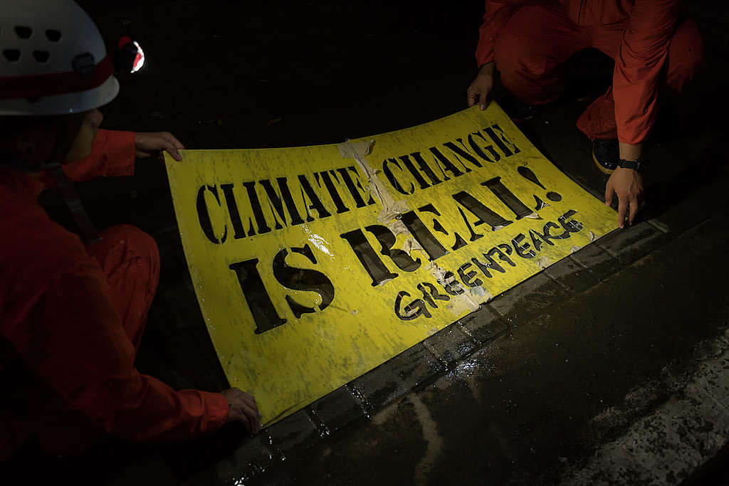 「氣候變化真實無疑！」綠色和平成員於東亞峰會（ASEAN Summit）場地外以高壓水槍「塗鴉」。 © Noel Guevara / Greenpeace