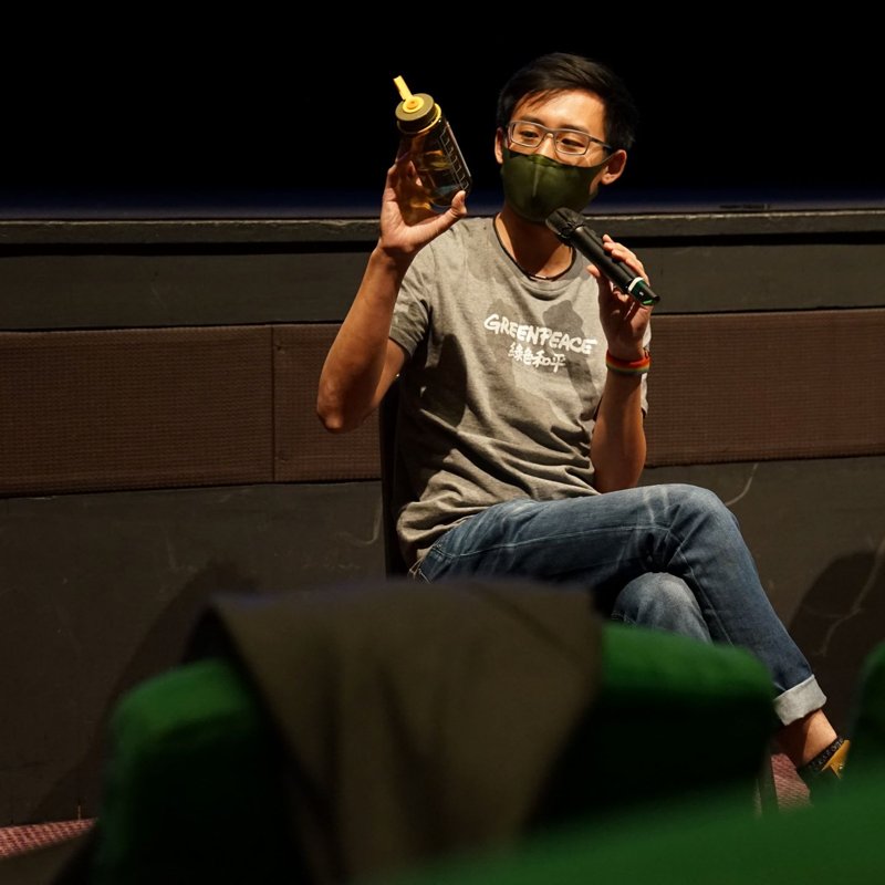 綠色和平項目主任伍漢林(Tom)拿起自己的水樽,分享氣候行動可在生活細節。© Alison Hui / Greenpeace