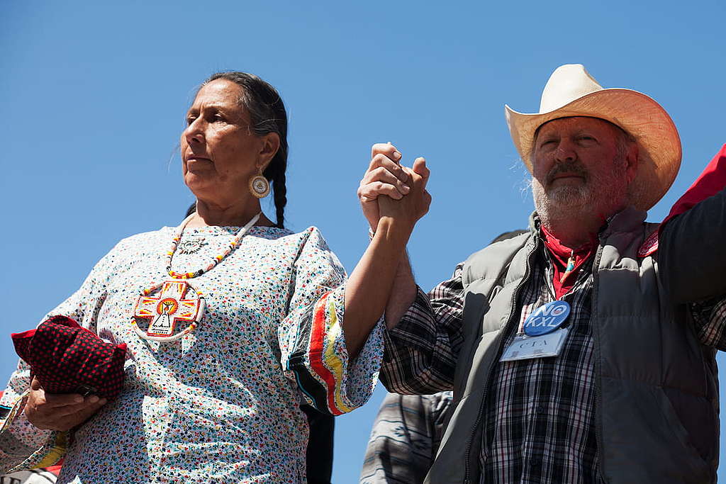 原住民的反擊—2014年牛仔印第安人聯盟在美國華盛頓林肯紀念堂發起抗議行動，向Keystone XL輸油管工程說不。他們向公眾展示抗議標語及巨型輸油管道模型。 © Douglas Reyes-Ceron / Greenpeace