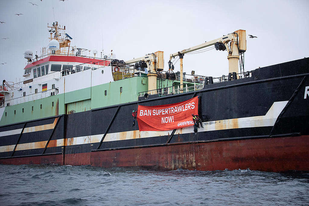 2020年10月，綠色和平完成首次投放巨石行動之際，在蘇格蘭東部一處保護區遇上長達117米的巨型工業拖網船；兩位行動者攀上船身展示標語，促請英國政府禁止大型工業漁船持續於保護區大肆「搜掠」。 © Suzanne Plunkett / Greenpeace