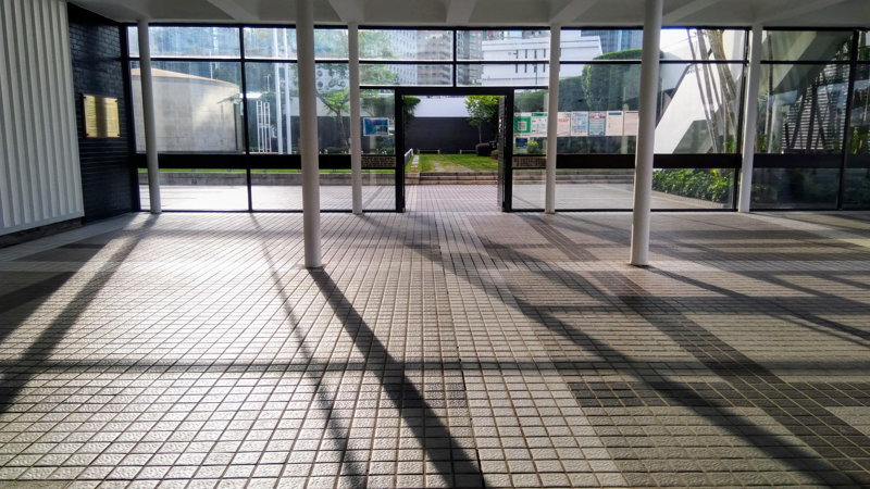 陽光穿透低座紀念公園入口,光影與建築編織的風景。© helen yip