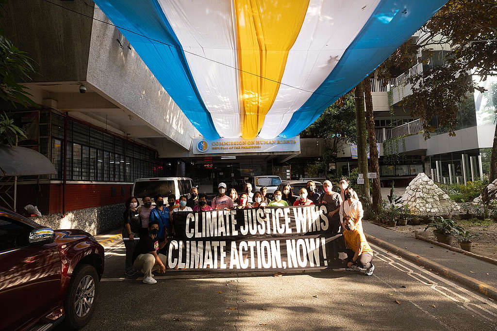 2022年5月6日菲律賓人權委員會舉行《國家氣候變化調查報告》新聞發佈會，當地社區人士到委員會辦公大樓，舉起「氣候公義勝利」和「馬上氣候行動」的標語。© Jilson Tiu / Greenpeace