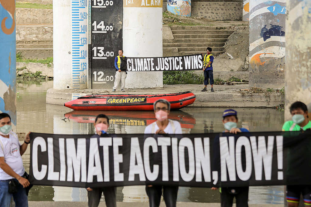 綠色和平連同氣候災難倖存者在菲律賓馬里基納河（Marikina River）洪水位標記旁舉行氣候行動及呼籲，要求當局支持氣候公義。每逢颱風季節，馬里基納河是菲律賓都會中受災最嚴重的城市之一。© Basilio H. Sepe / Greenpeace