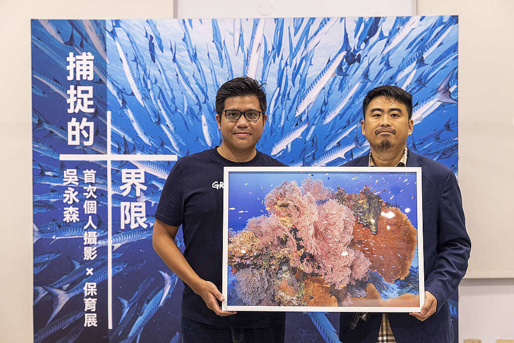 2022 年 7 月 22 日,國際著名攝影師吳永森(右)在攝影展開幕禮選出一幅攝於「潛水天堂」泰國斯米蘭海洋國家公園的水底照片,將由綠色和平項目主任鍾孟勳轉交當局,促請訂立《海洋保育法》。© Greenpeace / Yellow Huang