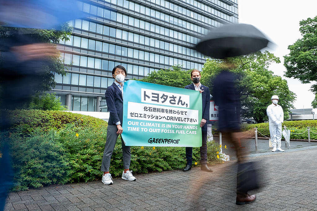 綠色和平東京辦公室行動者今年 6 月前往豐田汽車周年大會會場外，促請加速淘汰燃油車生產，實踐能源轉型。© Taishi Takahashi / Greenpeace