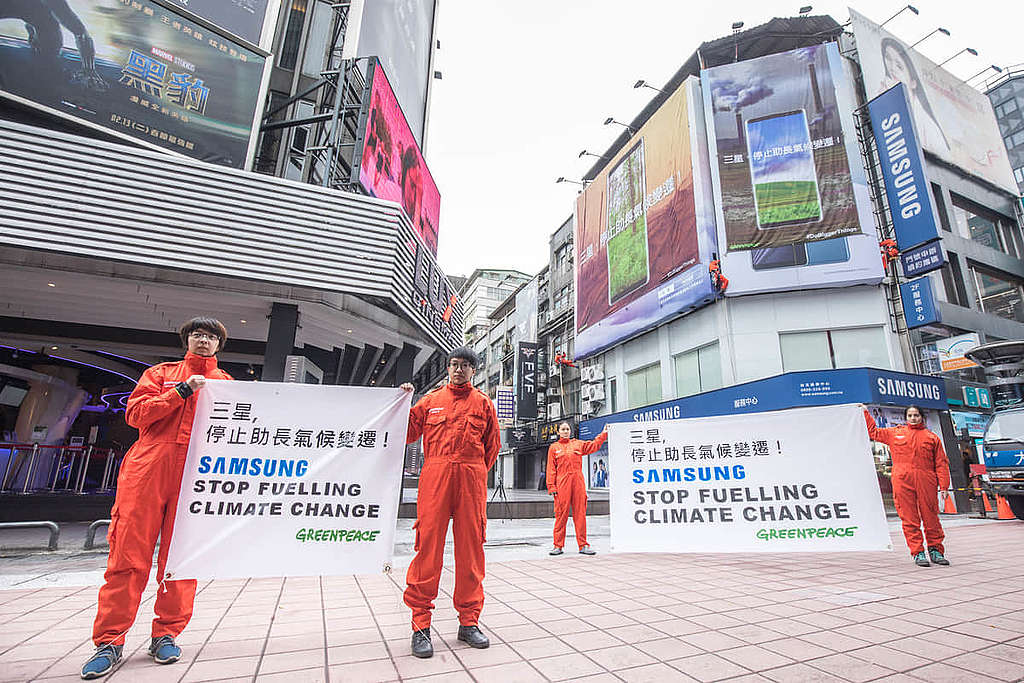 2018 年 1 月,綠色和平行動者在台北西門町的 Samsung 門市大樓外牆,掛上兩幅近 9 米長的巨型直幡,要求「三星,停止助長氣候變遷」。 © Chong Kok Yew / Greenpeace