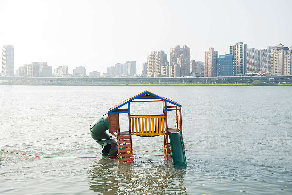 最寬廣的公園遊樂過……綠色和平台北辦公室在淡水河面矗立兒童遊樂場設備,模擬海平面上升場面,促請正視氣候危機。 © Greenpeace