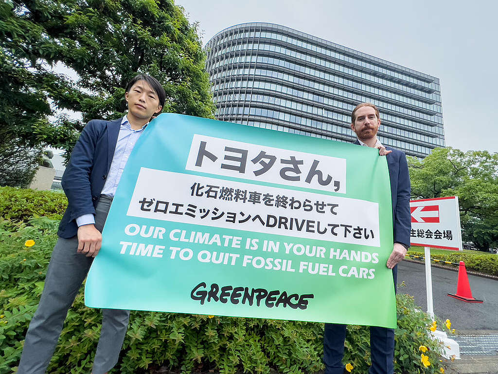 2022 年 6 月,綠色和平東京辦公室代表於豐田汽車年度股東大會會場外舉起倡議標語,促請這間全球最大汽車生產商加快電動車轉型。 © Taishi Takahashi / Greenpeace