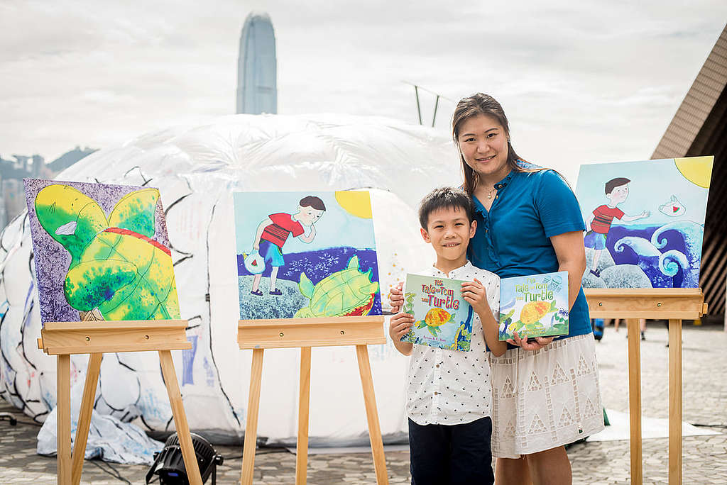Brian（左）2016 年與媽媽出席綠色和平「塑膠升級再造體驗展覽」，以《The Tale of Tom the Turtle》繪本畫作，展示保護海洋與自然生態的重要性。 © Tai Ngai Lung / Greenpeace
