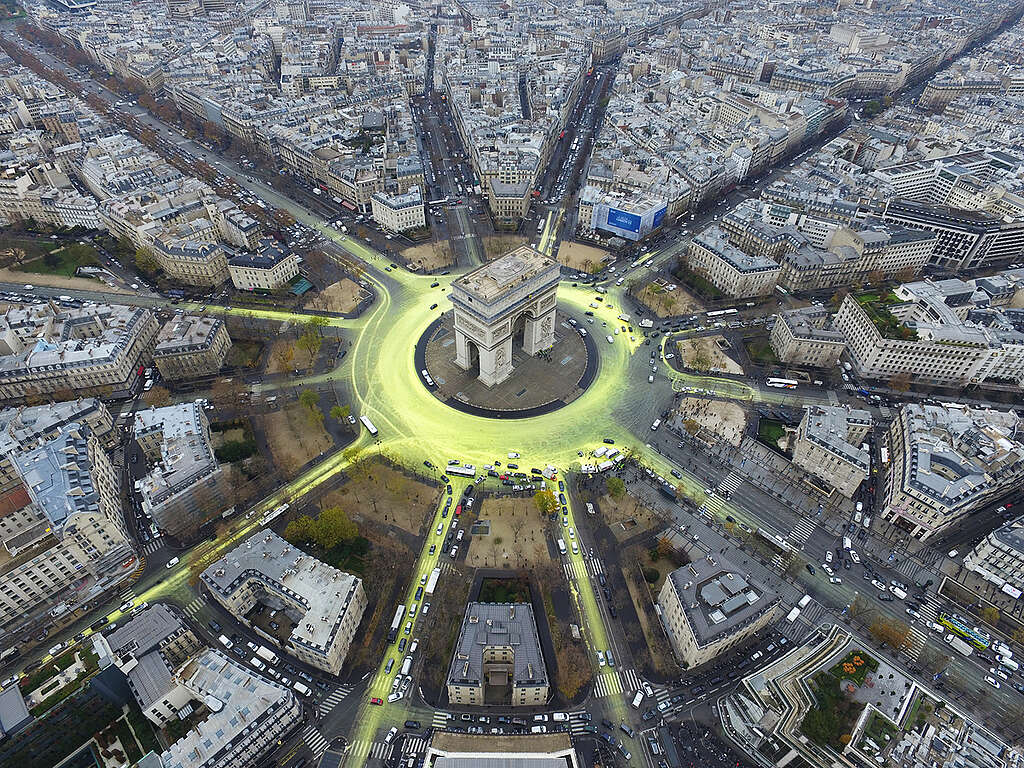 2015 年 12 月，在法國巴黎舉行的第 21 屆聯合國氣候變化大會談判進入衝刺階段，綠色和平行動者在圍繞凱旋門的道路噴上水溶性漆料，象徵可再生能源發展猶如旭日初升，曙光乍現。 © Greenpeace