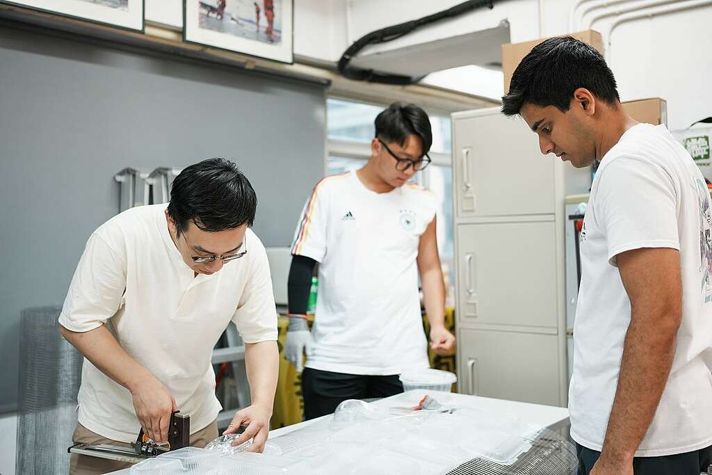 整件大型裝置藝術，並非一人之力所能完成，其中綠色和平義工 Alfred（左） 與 Praj（右）除了幫忙收集即棄餐具，亦落手落腳協助組裝。 © Greenpeace / JJ Tsui