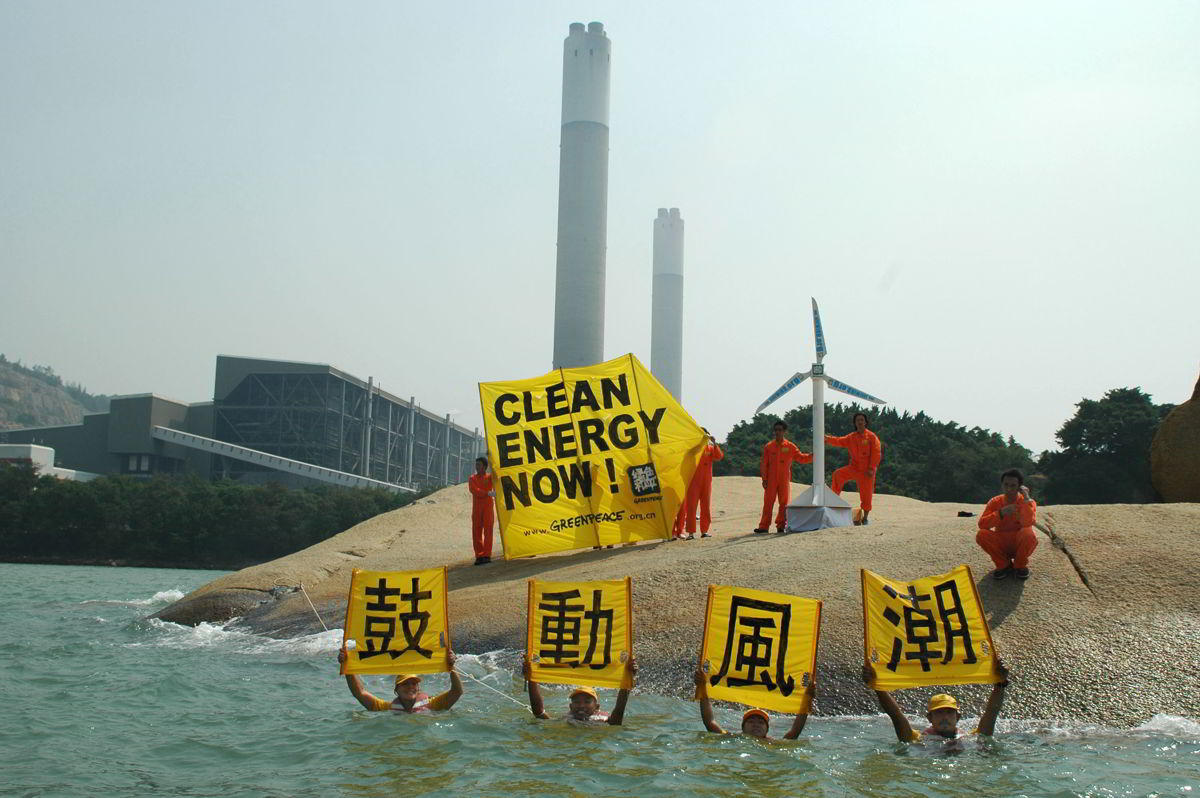 綠色和平香港辦公室推動兩電發展可再生能源多年；圖為2005年船艦彩虹勇士號「亞洲潔淨能源之旅」期間，行動者在青山發電廠外高舉「鼓動風潮」標語。 © Greenpeace / Alan Hindle