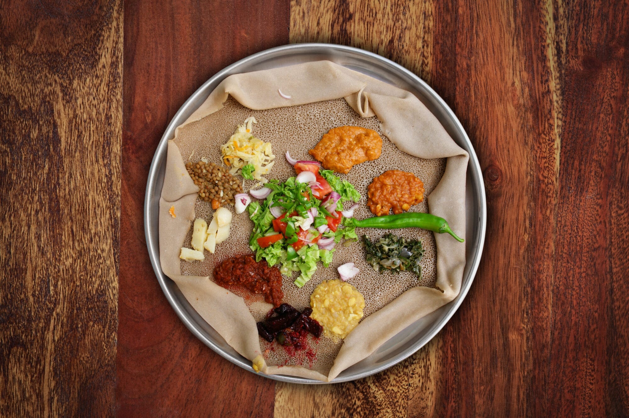 你可以在任何厄立特里亞或埃塞俄比亞餐廳，找到這款典型素菜拼盤。拼盤由多款燉豆和蔬菜組成，放在injera（酸麵餅）一併享用。 © narvikk