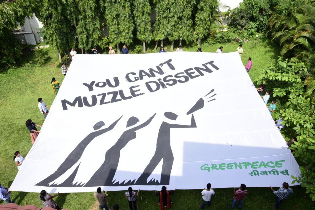 Greenpeace activists and staff unfurl a banner on World Environment Day
