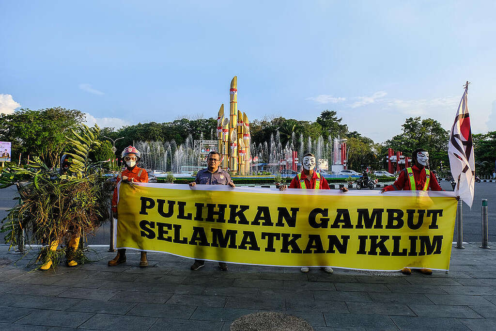 Aktivis lingkungan mengenakan topeng, serta membawa plakat, spanduk, dan balon yang menggambarkan gas berbahaya yang dihasilkan dari penggunaan batu bara saat mereka menggelar unjuk rasa selama rapat umum pemegang saham perusahaan tambang batu bara Adaro di depan gedung Hotel Raffles di Jakarta, Indonesia. Greenpeace Indonesia, bersama Market Forces, dan Enter Nusantara menyerukan Adaro untuk segera menghentikan ekspansi batu bara yang telah menyebabkan krisis iklim dan memulai transisi menjauh dari batu bara setelah bank-bank besar memutuskan hubungan dengannya.