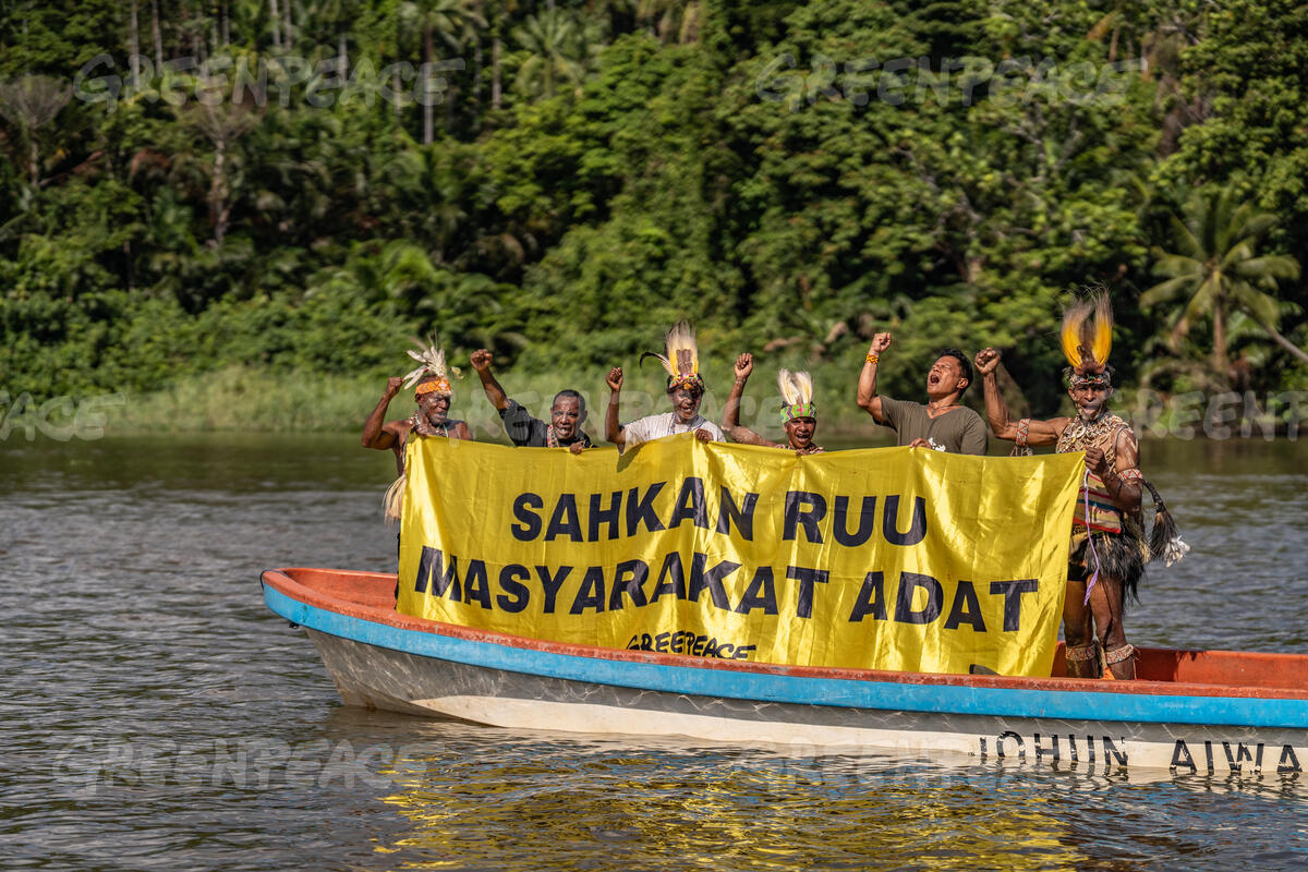 Banner Protest Action on River Digoel, Boven Digoel Greenpeace Indonesia activist with Papuan Indigenous people from Wambon and Awyu tribe unfurl a banner that reads "Legalize The Indigenous People Bill" on a boat in the area of their tribe forest, on Digoel River, Boven Digoel, South Papua.