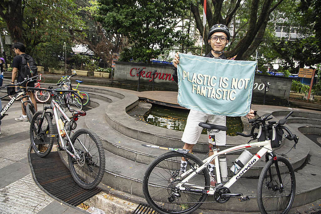 Biking to Plastic Free Parade Picnic in Bandung Bikers pose with a banner bearing the "Plastic is Not Fantastic" inscription during Bike Tour on Plastic Free Parade picnic in Bandung.