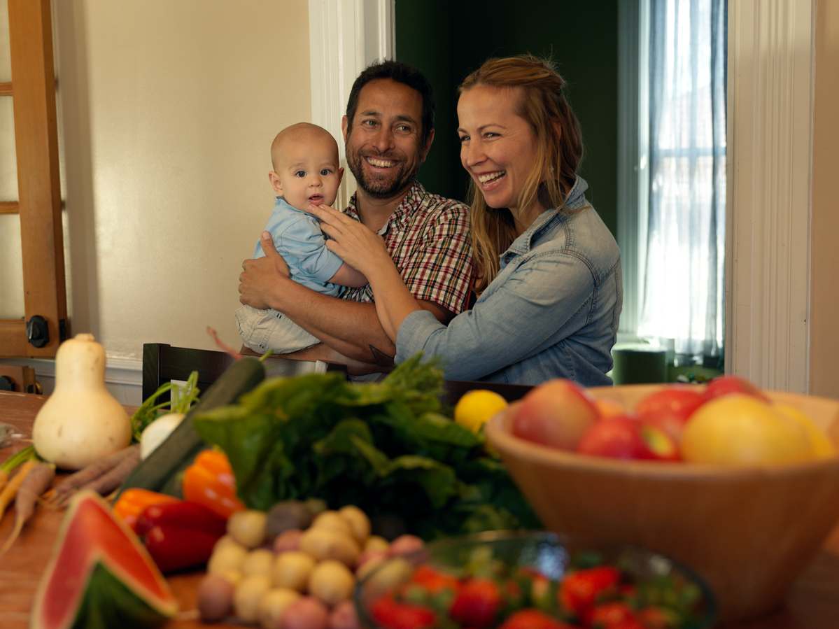 Family with their local produce © Peter Caton / Greenpeace