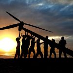 Raising a wind turbine on the beach at dawn in Durban, South Africa.  