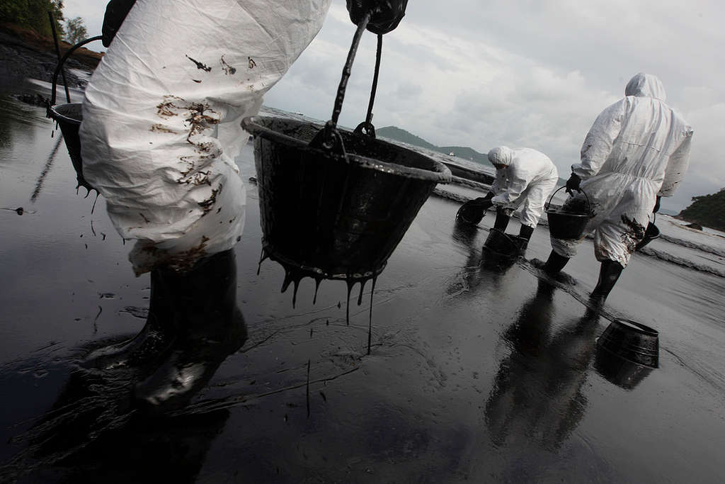 Rescue workers and local volunteers attempt to clean up the oil spill at Ao Phrao beach in Ko Samet, Rayong Province. (2013). © Roengrit Kongmuang / Greenpeace