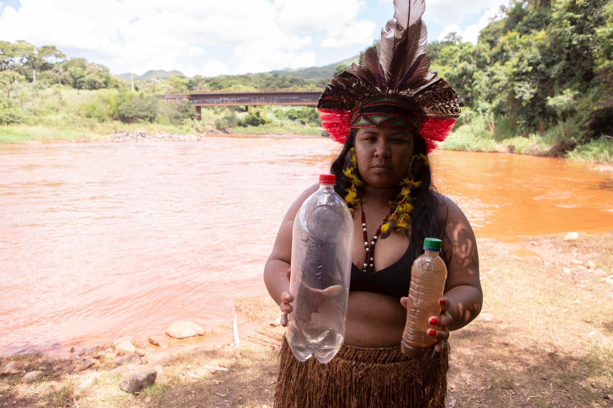 Werymerry Hã-hã-hãe with samples of water before and after the mud reached the Paraopeba River. © Nilmar Lage