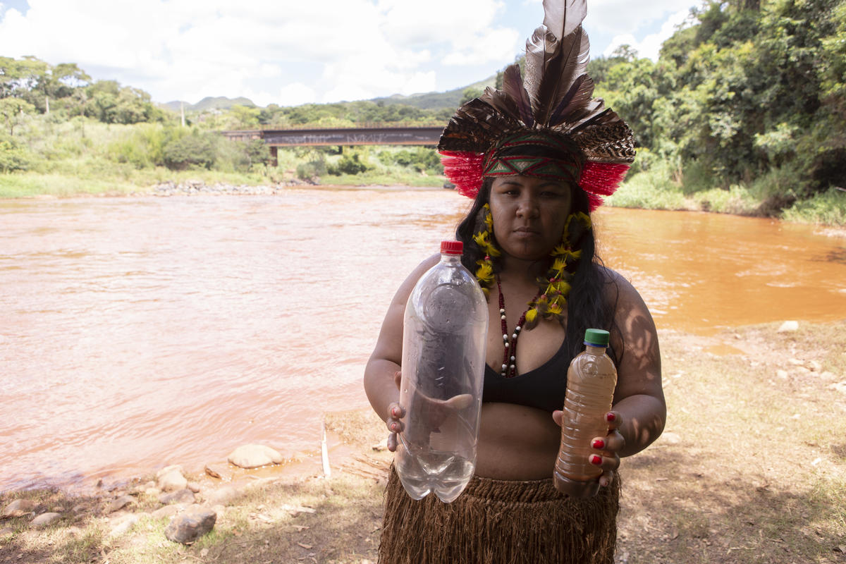 Werymerry Hã-hã-hãe with samples of water before and after the mud reached the Paraopeba River. © Nilmar Lage