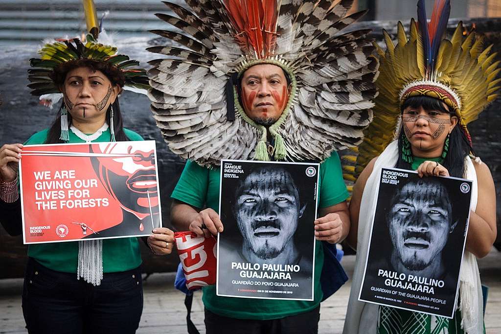 Indigenous Leaders Nara Bare, Kretã Kaygang and Celia Xakriabá hold signs of Paulo Paulino Guajajara in a demonstration in fron of the European Parliament in Brussels, Begium, on November 5th. © Midia Ninja