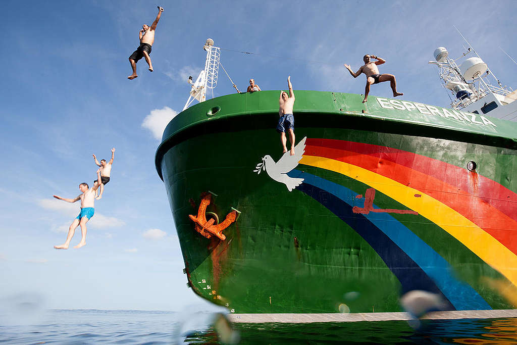 Greenpeace crew jump from the MY Esperanza during a swim stop. © Pierre Baelen / Greenpeace