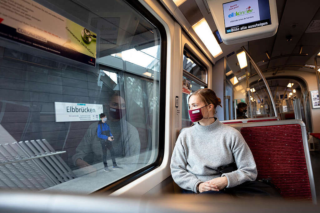 A woman wears a mouth and nose protection mask in public transport. © Daniel Müller / Greenpeace A woman wears a mouth and nose protection mask in public transport.