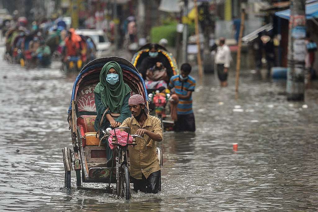 Cycle rickshaw pullers wade through a waterlogged street carrying their passengers after a heavy downpour in Dhaka, Bangladesh. © Munir Uz Zaman/AFP via Getty Images Cycle rickshaw pullers wade through a waterlogged street carrying their passengers after a heavy downpour in Dhaka, Bangladesh. © Munir Uz Zaman/AFP via Getty Images