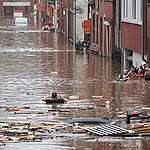 A woman is trying to move in a flooded street following heavy rains in Liege. © Bruno Fahy/Belga/AFP / Getty Images