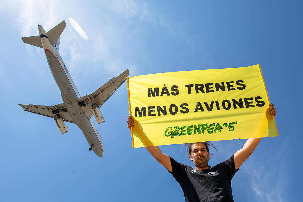 Activists from Greenpeace Spain hold a banner that reads: "more trains and fewer planes". © Greenpeace / Pablo Blázquez Greenpeace Spain hold a banner that reads: "more trains and fewer planes". © Greenpeace / Pablo Blázquez