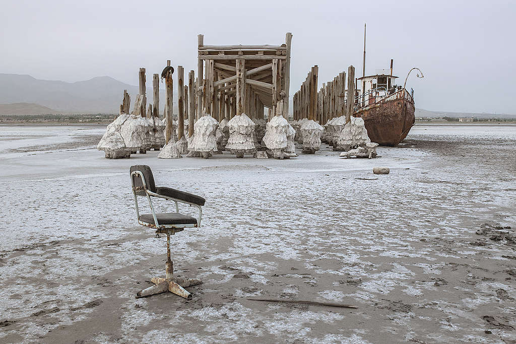 On the shore of Sharafkhaneh port in Iran that is now completely dry with no water in sight, an abandoned ship sits wedged against a pier.