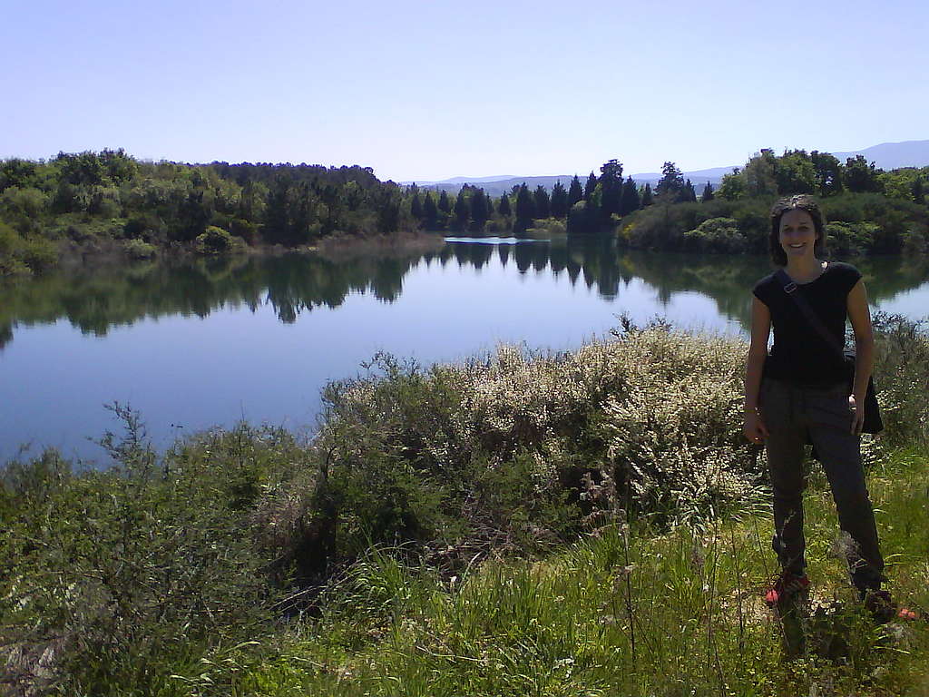 Montse Valencia León (Concello de Lobeira, Baixa Limia, Ourense, Galicia) stands on the grass next to a lake where she lives in Spain.