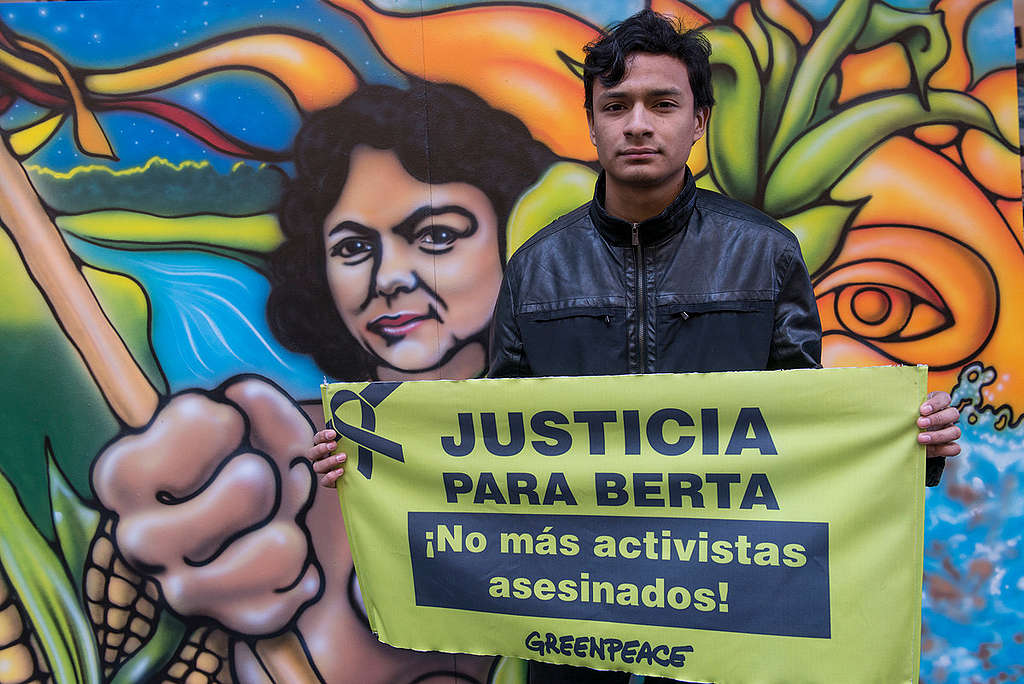 Salvador Zuniga Caceres, son of activist Berta Caceres, holding a sign saying Justice for Berta.