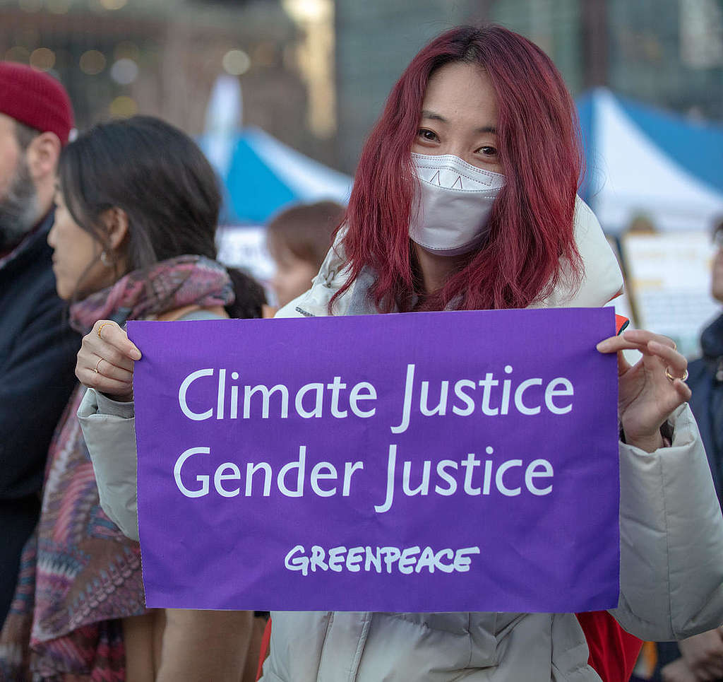 Staff member of Greenpeace Seoul office joining the International Women's Day march held in Gwanghwamun, Seoul and holding a sign reading Climate Justice Gender Justice (March 2019).