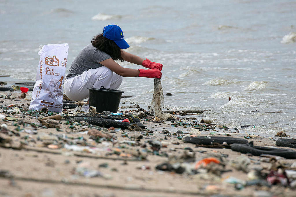 Amika Jamjansri collecting trash along Wonnapa beach in Chonburi province, Thailand, as part of a plastic brand audit activity from the Break Free from Plastic campaign.