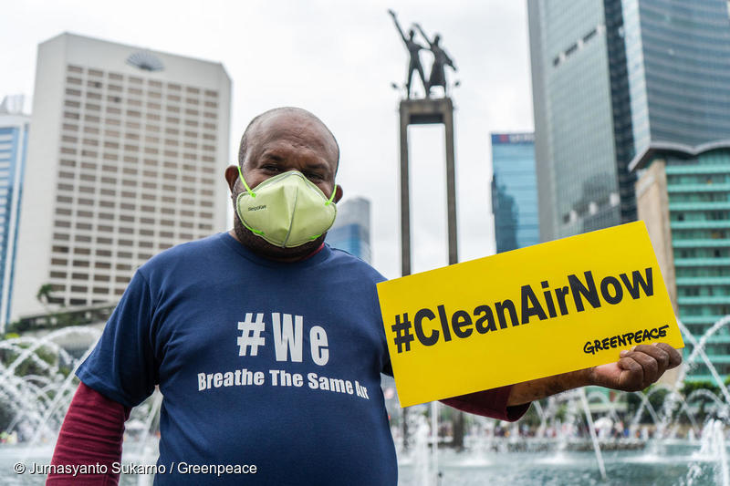 Greenpeace activist holds a banner reads #CleanAirNow during an air pollution campaign in Jakarta.