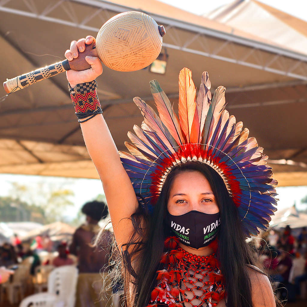 Indigenous Woman holding an instrument with her fist up