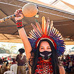 Indigenous Woman holding an instrument with her fist up