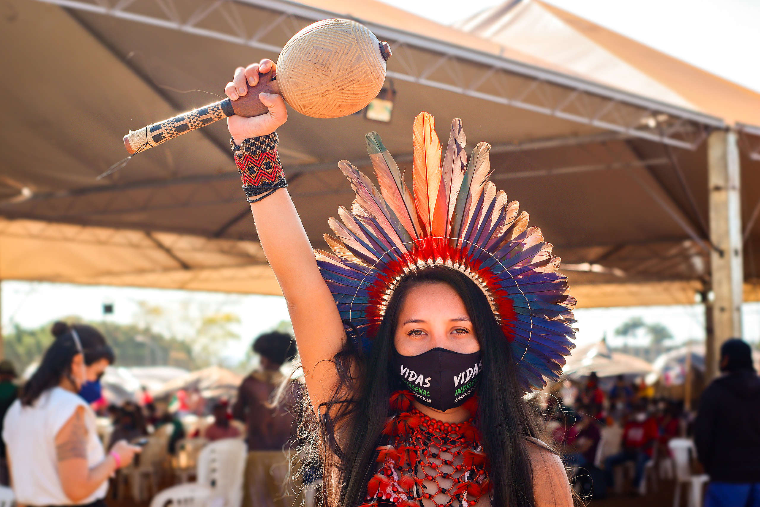 Indigenous Woman holding an instrument with her fist up