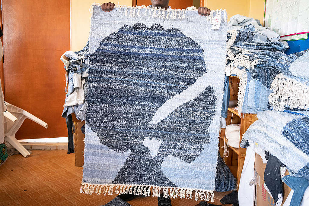 Fast Fashion Research in Kenya. © Kevin McElvaney / Greenpeace A beautiful carpet woven out of used jeans by the Kenyan organisation Africa Collects Textiles. The Global North can learn from the designers, Mitumba traders, upcyclers and waste pickers in East Africa how to value and take care of clothes already in the system. © Kevin McElvaney / Greenpeace
