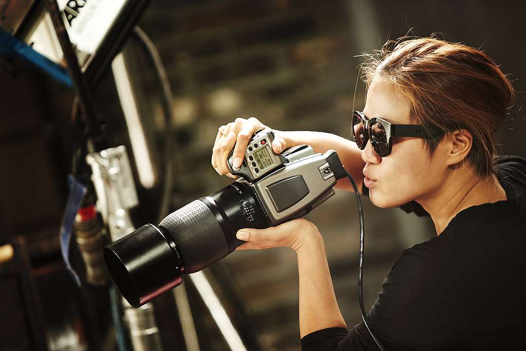 A woman in sunglasses holding a photo camera