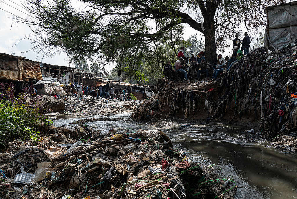 Fast Fashion Research in Kenya. The Nairobi River which runs through Gikomba market is clogged up with textile waste. © Kevin McElvaney / Greenpeace